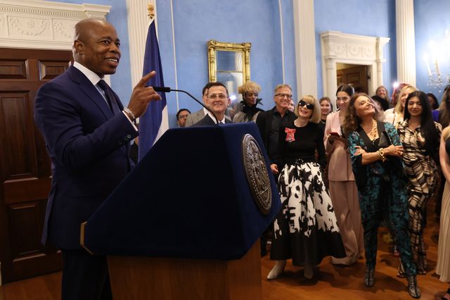Mayor Eric Adams speaks behind a podium during a New York Fashion Week reception hosted by the mayor's office , Vogue, and the Council of Fashion Designers of America at Gracie Mansion with Anna Wintour and Diane Von Furstenberg looking on in the crowd.